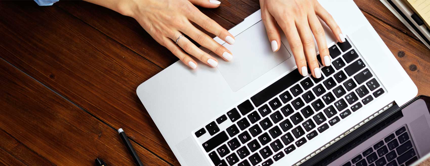 Background of hands typing on a laptop